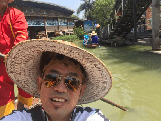 Image of Limbu smiling on a boat in a river